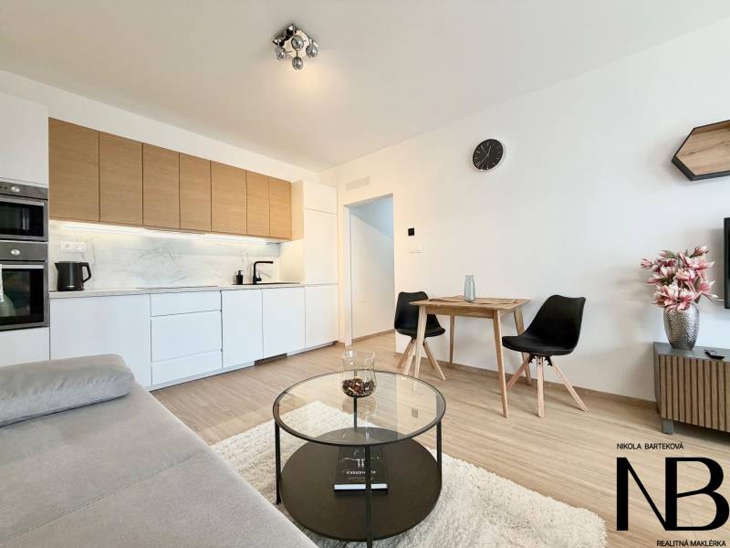 Küche in einer Einzimmerwohnung mit Holzboden und bequemen Sitzgelegenheiten.