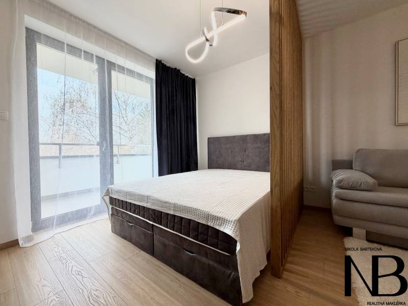 Schlafzimmer in einer Einzimmerwohnung mit Bett, Sofa und Holzboden.