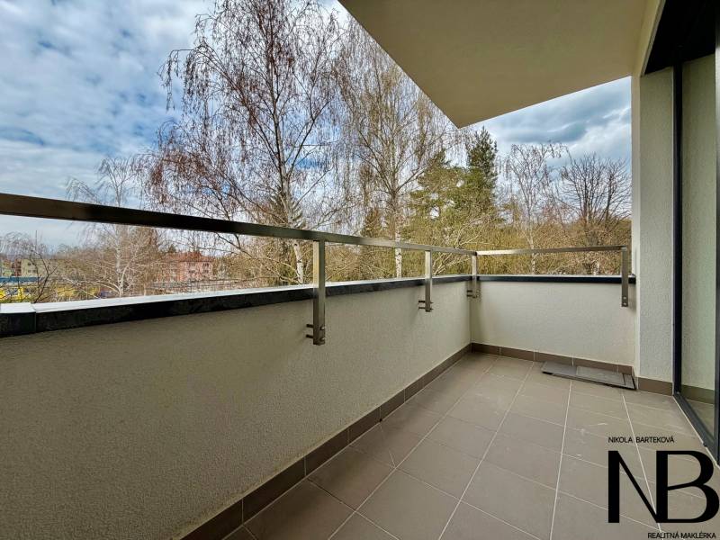 Der Balkon einer Einzimmerwohnung in der Soblahovská-Straße in Trenčín mit Blick auf die Bäume.