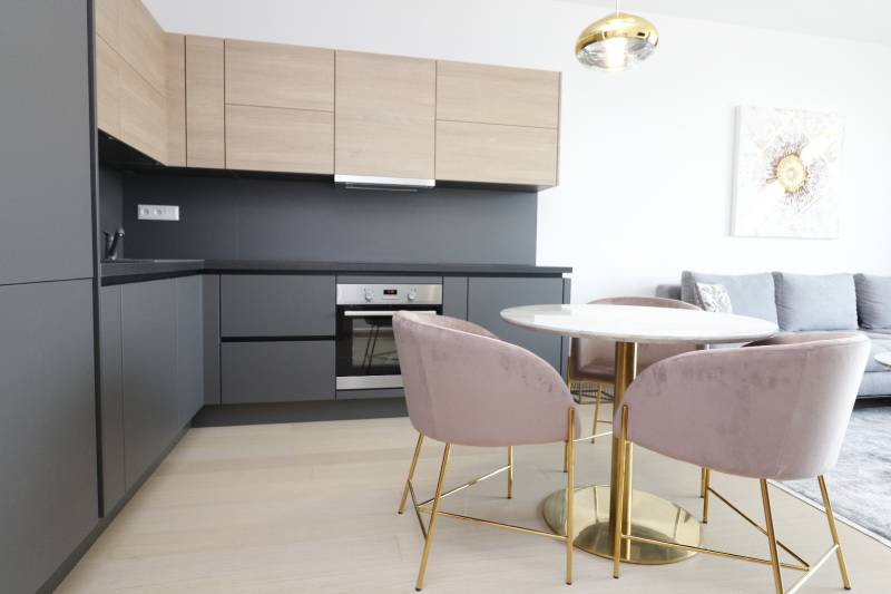 Küche in einer 2-Zimmer-Wohnung mit Holzboden und stilvollem Tisch.