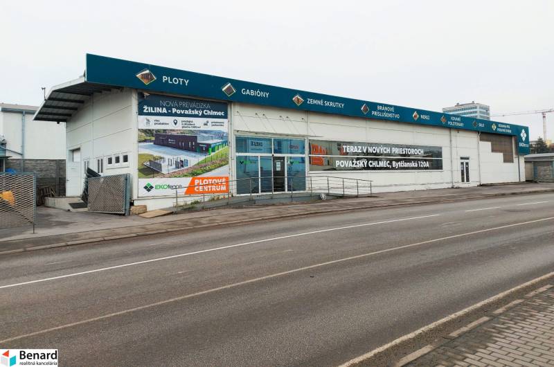 Geschäftsräume in der Kamenna-Straße in Žilina mit Werbeaufschriften und einem leeren Parkplatz.