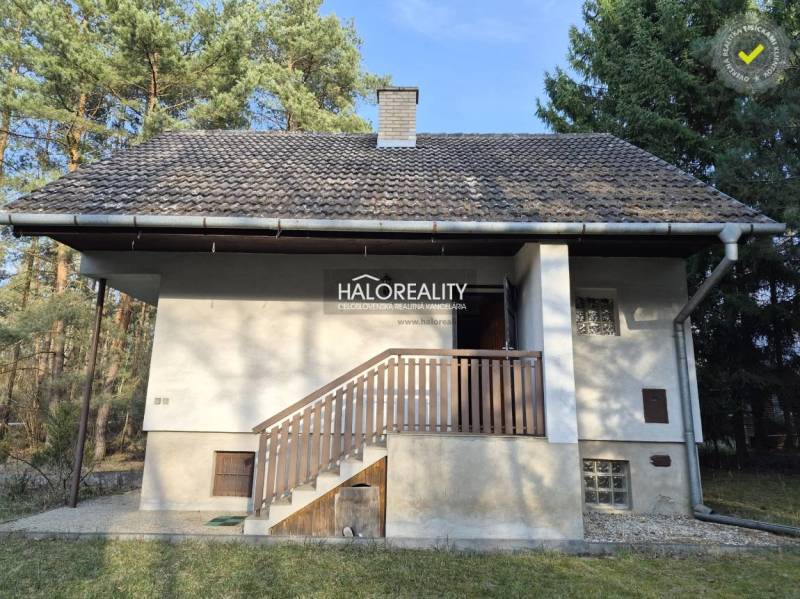 Eine Hütte in Borský Svätý Jur mitten im Wald mit Balkon und schrägem Dach.