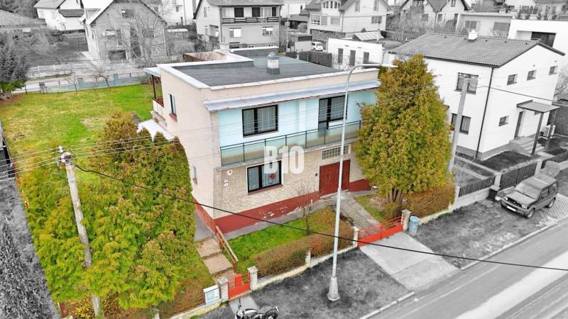 Ein Einfamilienhaus in Martin mit Flachdach, Garten und umliegenden Häusern.