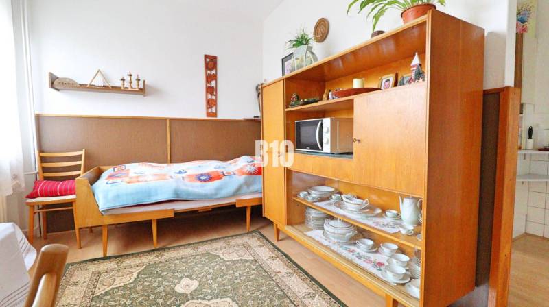 Ein Zimmer in einem Einfamilienhaus mit einem Bett, einer Vitrine und einem Boden mit Holzdekor.