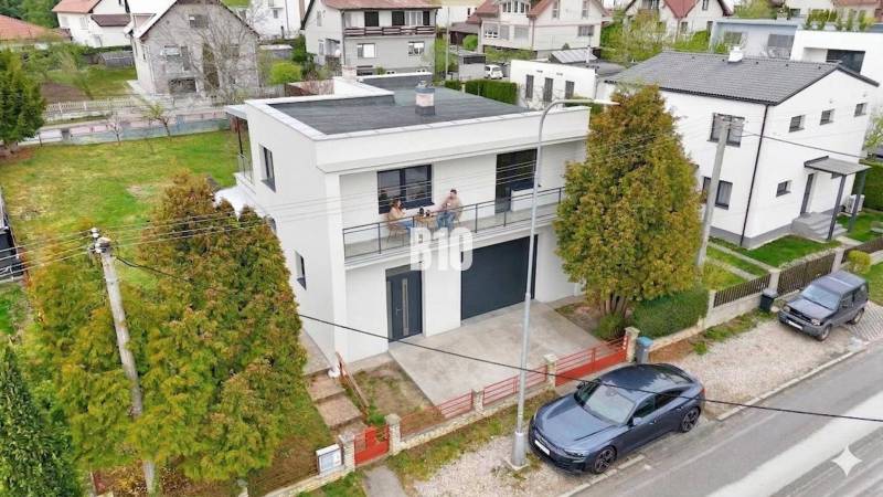 Einfamilienhaus in Martin mit Balkon, Garage und umliegendem Grün.