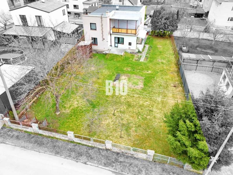 Ein Einfamilienhaus in Martin mit Garten und Bäumen, umgeben von einem Zaun für Privatsphäre.