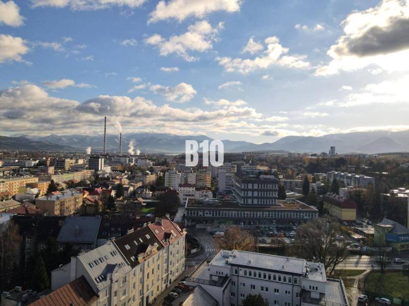 Die Stadt Žilina mit Panorama, Wohnhäuser und Industriegebiet im Vordergrund.