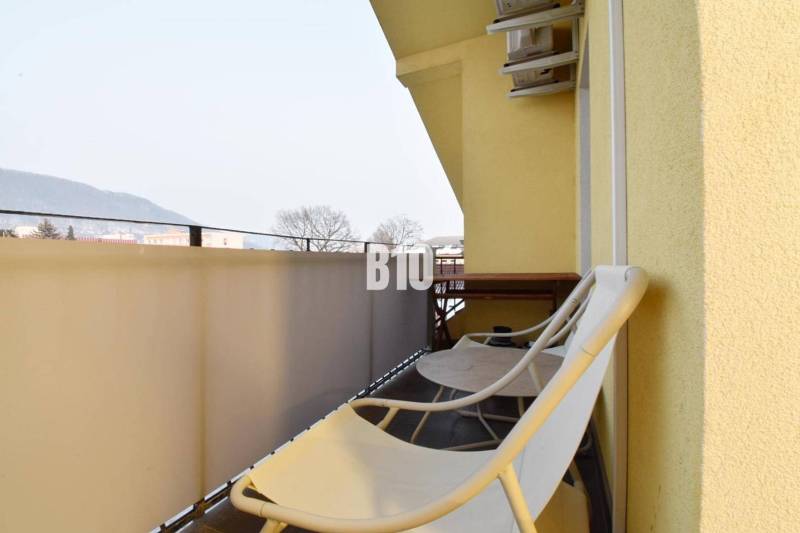 Balkon einer 4-Zimmer-Wohnung in Žilina mit Stühlen und Blick auf die Berge.