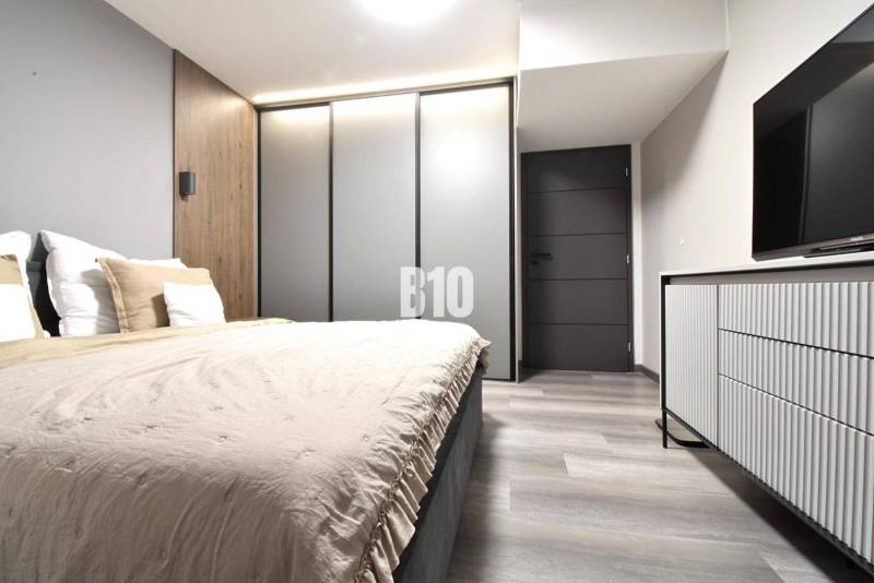 Schlafzimmer mit Holzboden und Kleiderschrank in einer 4-Zimmer-Wohnung.