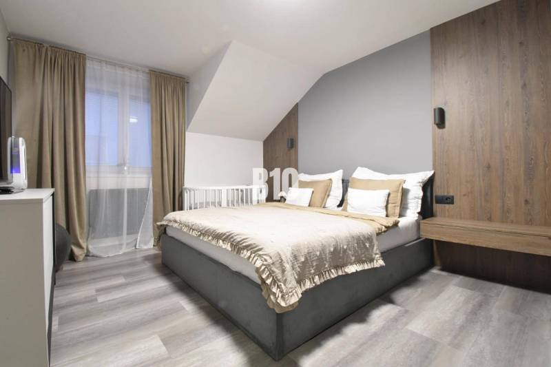 Helles Schlafzimmer mit bequemem Bett in einer 4-Zimmer-Wohnung, Boden mit Holzdekor.