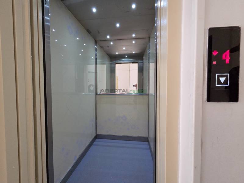 Der Innenraum des Aufzugs mit Leuchten und Spiegel zeigt die 4. Etage in einer 3-Zimmer-Wohnung.