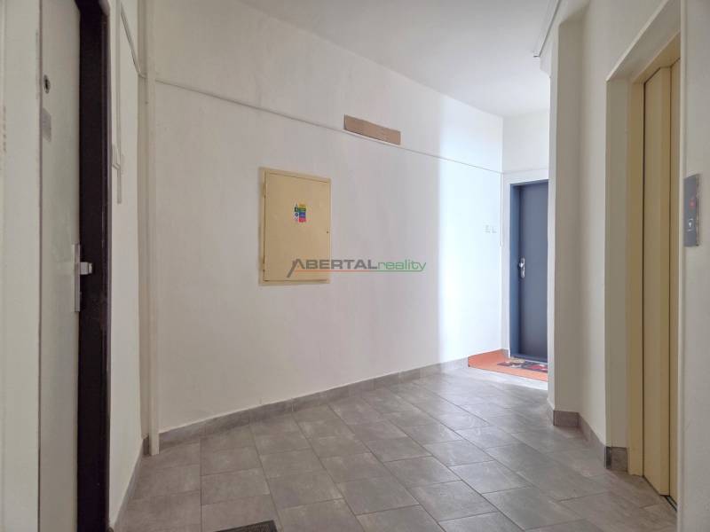 Der Flur in der 3-Zimmer-Wohnung mit hellen Wänden und grauen Fliesen.