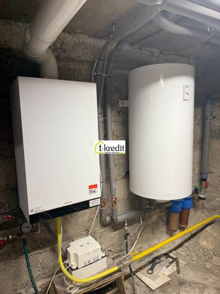 Kessel mit Boiler im Heizraum eines Einfamilienhauses, einschließlich Leitungen und Rohre.