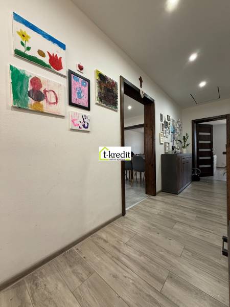 Innenraum eines Einfamilienhauses mit dekorativen Bildern an den Wänden und einem Boden mit Holzdekor.