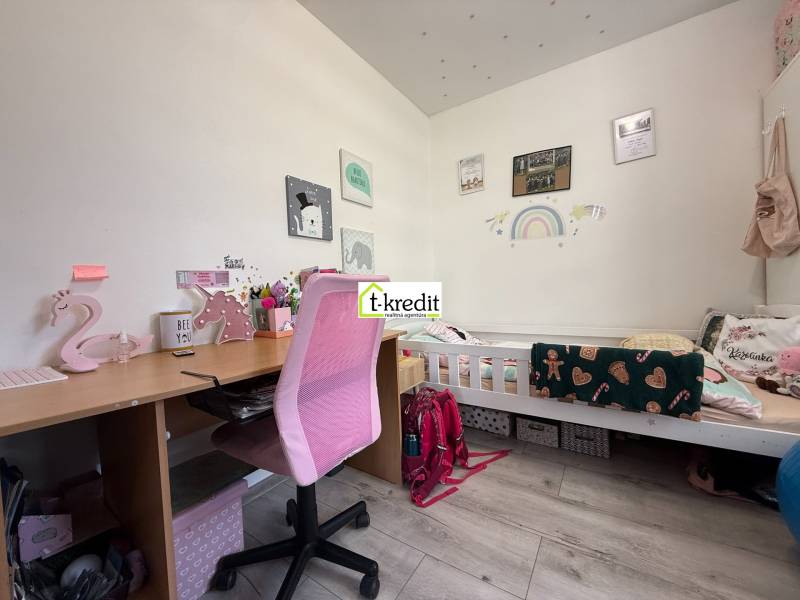 Kinderzimmer mit Schreibtisch, rosa Stuhl und Bett mit Dekor für ein Kind.