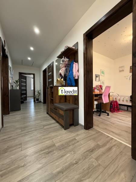 Flur in einem Einfamilienhaus mit Holzboden, Arbeitsecke und Garderobenwand.