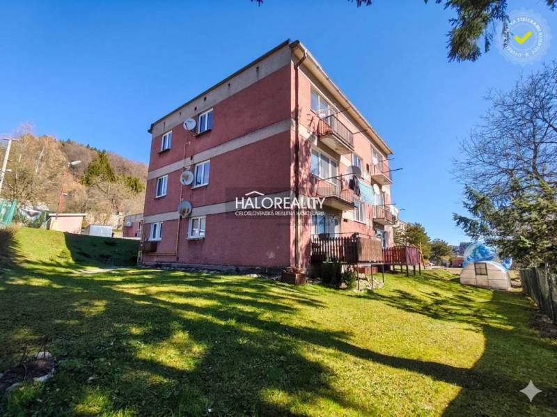 Ein Wohnhaus mit einer 3-Zimmer-Wohnung in Štiavnické Bane, umgeben von grünem Rasen.