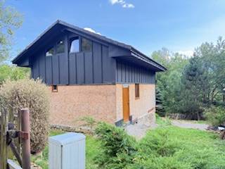 Eine Hütte in der ländlichen Gegend von Horná Mariková, umgeben von Grün und Bäumen.