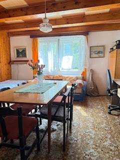 Wohnzimmer in einem Einfamilienhaus mit Esstisch und Blumen darauf.