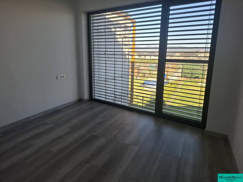 Ein Interieur in einem Einfamilienhaus mit großen Fenstern und einem Boden in Holzoptik.