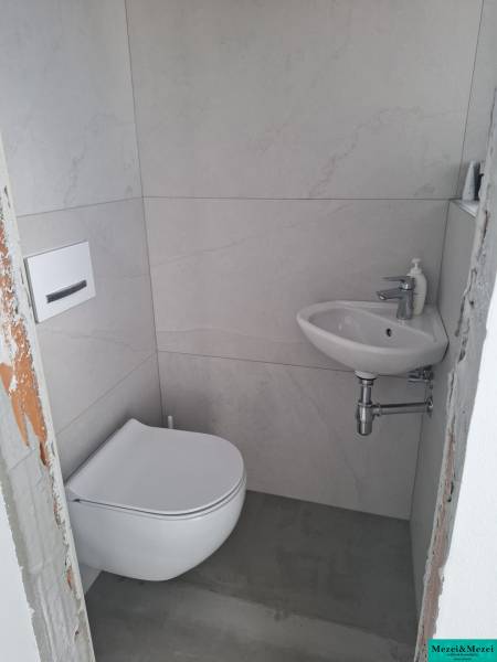 Kleines Badezimmer im Einfamilienhaus mit Waschmaschine und Waschbecken.