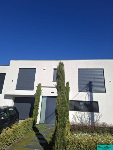 Ein Einfamilienhaus in Zvončín mit einer minimalistischen Fassade und einem gepflegten Vorgarten.