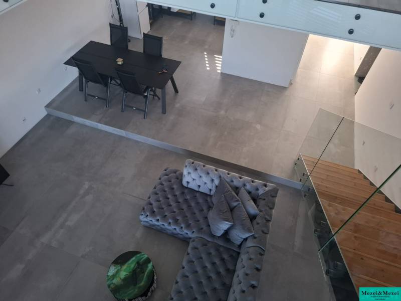 Innenraum eines Einfamilienhauses mit Blick auf den Esstisch, das Sofa und die Treppe.