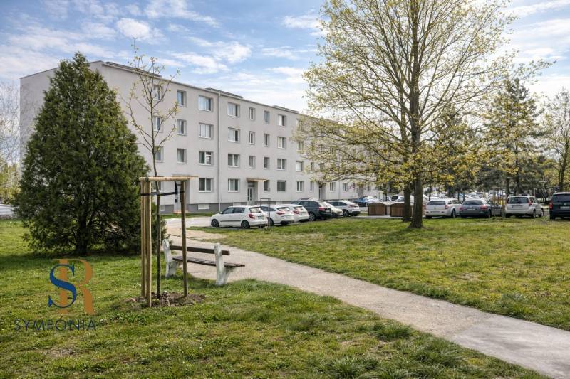 Biela budova s priestranným okolím.png