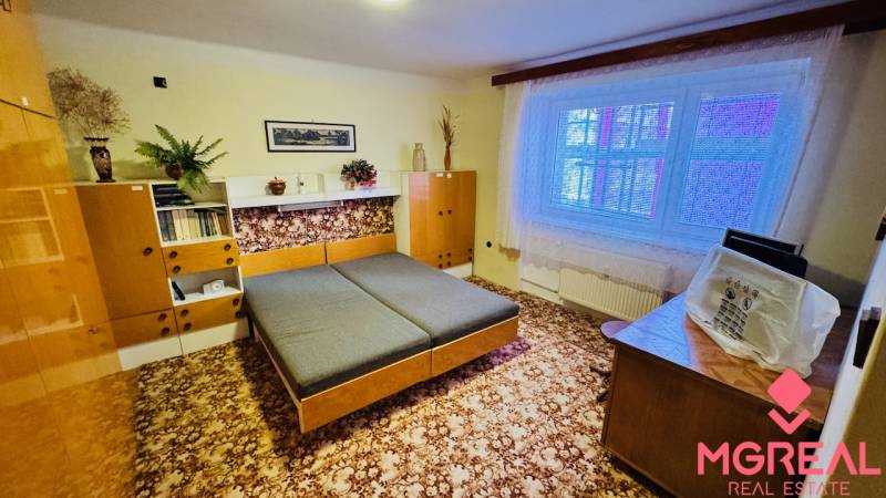 Ein Zimmer in einer 3-Zimmer-Wohnung mit Holzmöbeln und einem Teppich auf dem Boden.