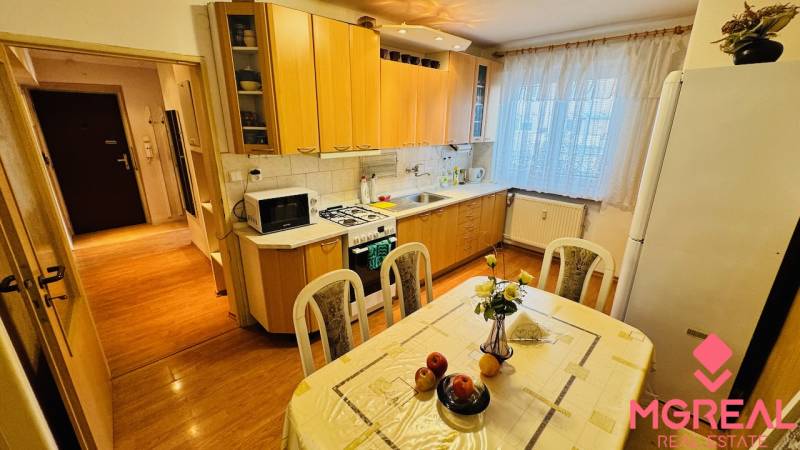 Küche in einer 3-Zimmer-Wohnung mit Holzboden und Esstisch.