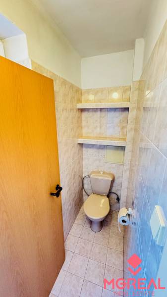 Toilette mit Keramikfliesen und Ablagefächern, Teil einer 3-Zimmer-Wohnung.