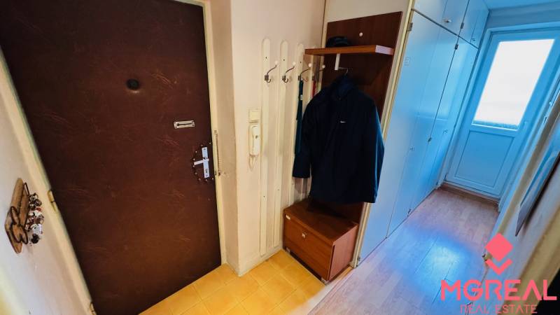 Eingangsflur mit Garderobe, Schrank und Boden mit Holzdekor in einer 3-Zimmer-Wohnung.