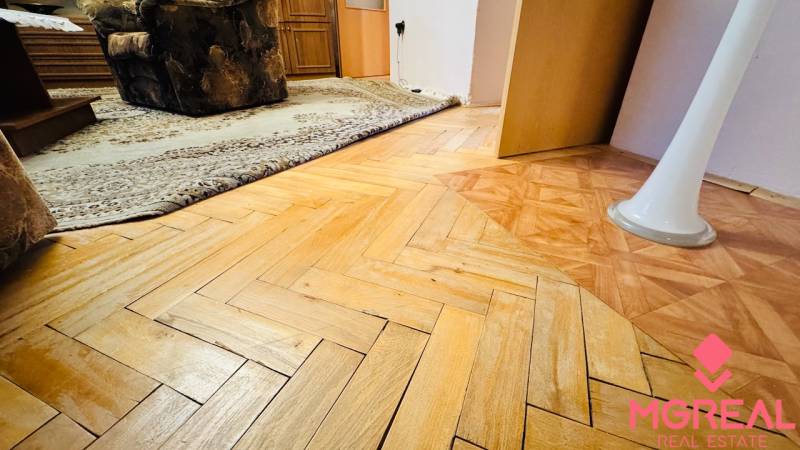 Boden mit Holzdekor in einer 3-Zimmer-Wohnung, Teppich und Möbel im Innenraum.