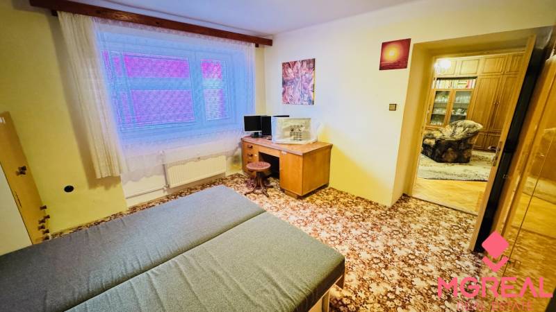 Ein Zimmer in einer 3-Zimmer-Wohnung mit Teppichboden, Schreibtisch und Bett.
