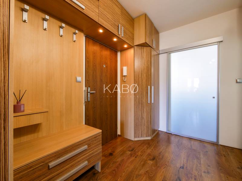 Eingangsflur in einer 3-Zimmer-Wohnung mit Holzboden und Einbaumöbeln.