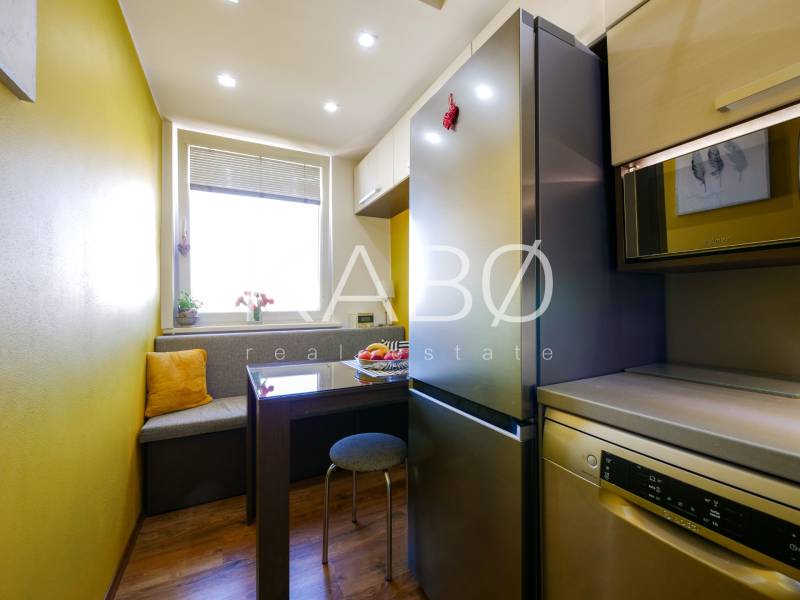 Küche in einer 3-Zimmer-Wohnung mit Holzboden, Essbereich mit Bank.