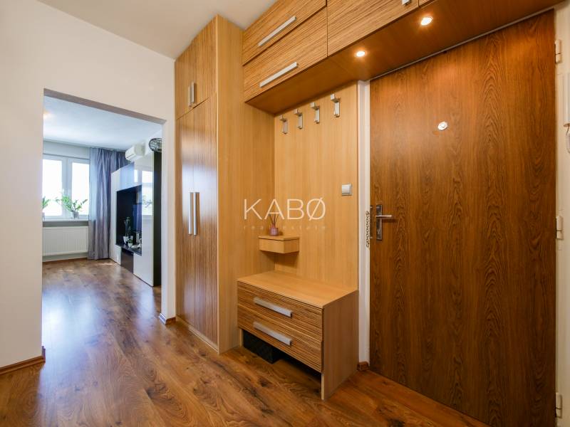 Innenraum einer 3-Zimmer-Wohnung mit Flur, Holzschränken und einem Boden mit Holzdekor.