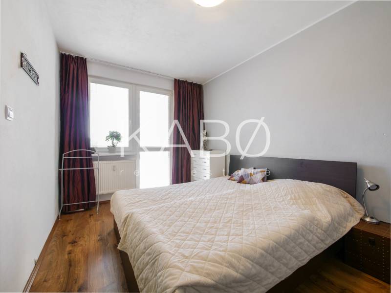 Schlafzimmer in einer 3-Zimmer-Wohnung mit Holzboden und Bett.
