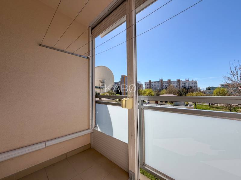 Balkon in einer 3-Zimmer-Wohnung mit Blick auf Grünflächen und Gebäude in Nitra in der Murániho-Straße.