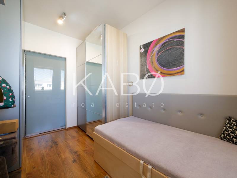 Kinderzimmer in einer 3-Zimmer-Wohnung mit Holzboden und abstrakter Kunst an der Wand.