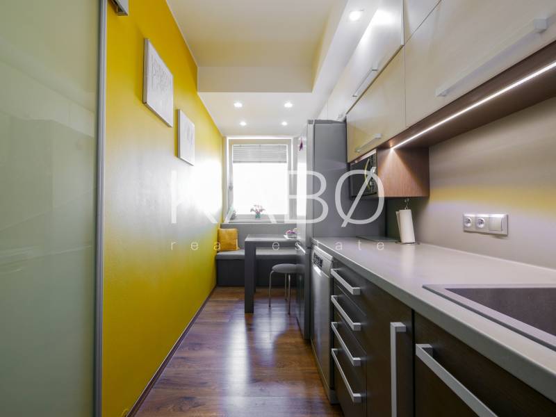 Küche in einer 3-Zimmer-Wohnung mit Holzboden und gelben Wänden.
