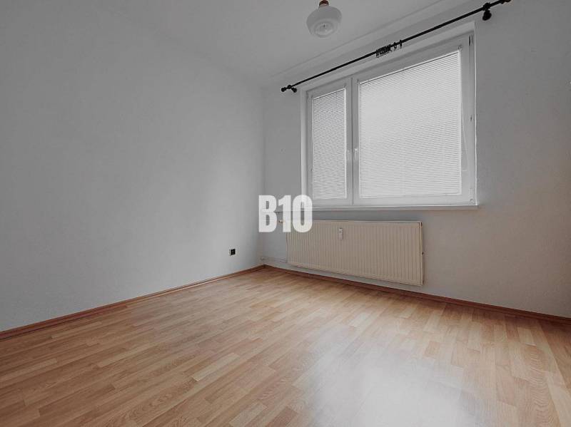 Ein leerer Raum mit Wänden in einer 3-Zimmer-Wohnung, Holzboden, großes Fenster.