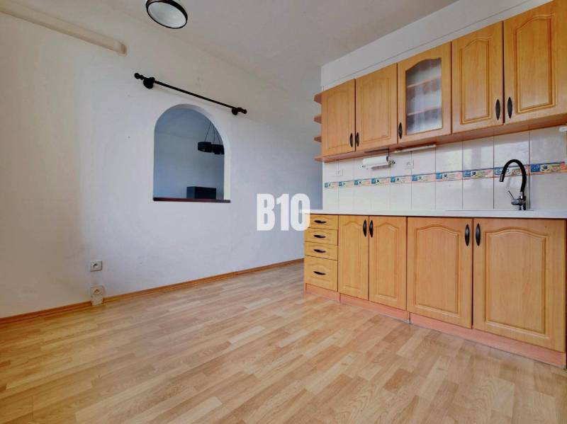 Küche in einer 3-Zimmer-Wohnung mit Holzboden und Einbauschränken.