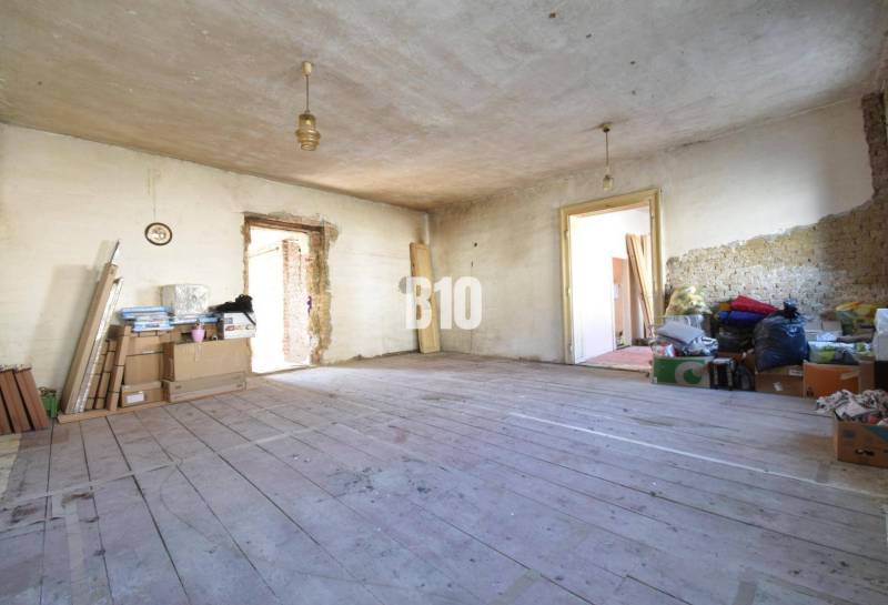 Unordentliches Zimmer in einem Einfamilienhaus mit Holzboden und Baumaterial.