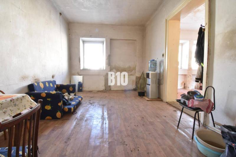 Wohnzimmer in einem Einfamilienhaus mit Holzboden, älteren Möbeln.