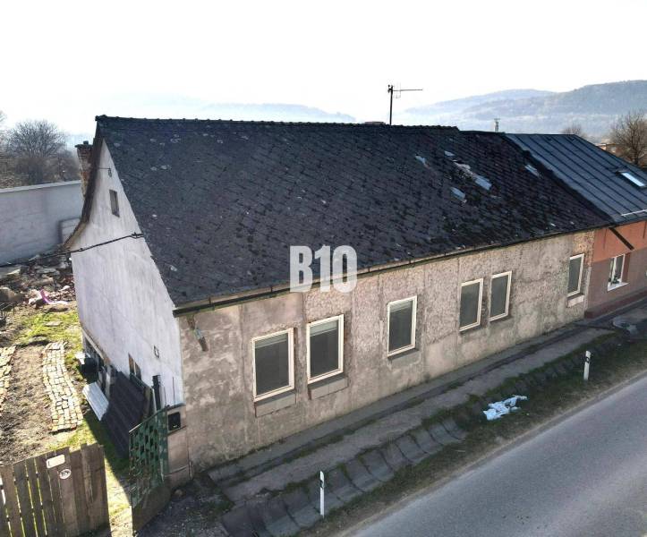 Ein Einfamilienhaus in Bytča mit abgenutztem Dach und Putz, neben der Hauptstraße.