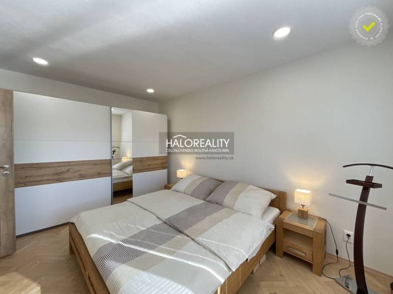 Helles Schlafzimmer in einer Einzimmerwohnung mit Holzboden und Einbauschrank.