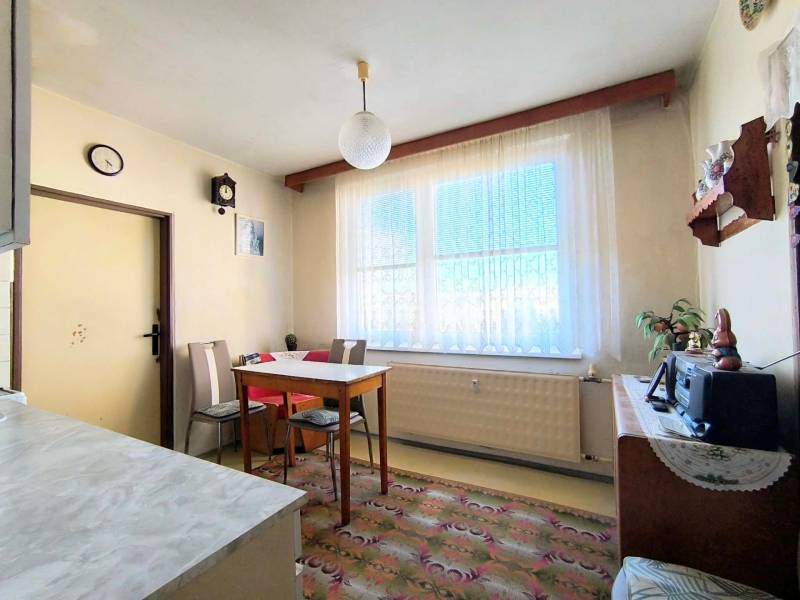 Esszimmer mit einfachen Möbeln in einer 3-Zimmer-Wohnung, Boden mit dekorativem Teppich.