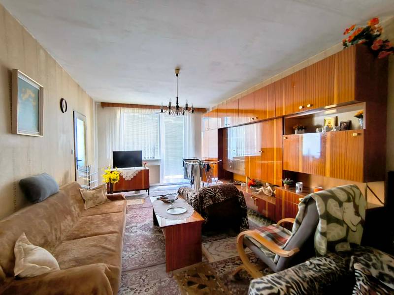 Wohnzimmer in einer 3-Zimmer-Wohnung mit Holzboden und einer Sitzgarnitur.