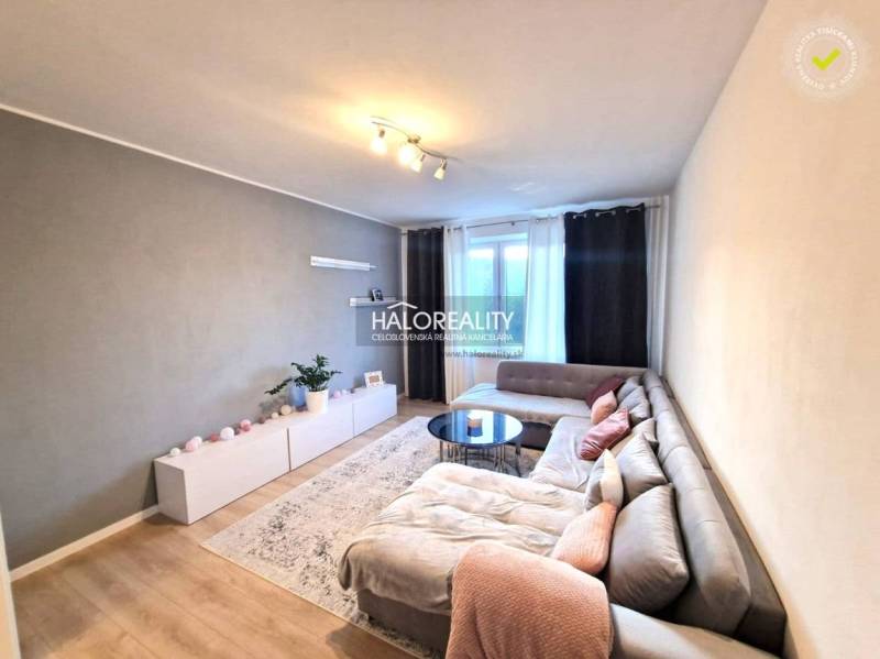 Wohnzimmer in einer 3-Zimmer-Wohnung mit Holzboden und einer Eckcouch.